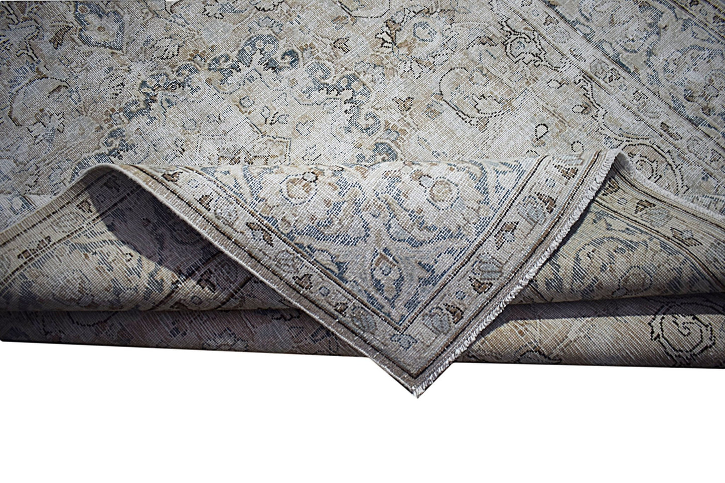 A vintage Persian Kerman rug featuring a faded floral medallion pattern in blue and beige tones.