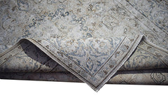A vintage Persian Kerman rug featuring a faded floral medallion pattern in blue and beige tones.