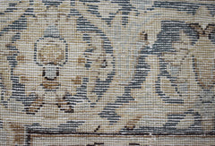 A close-up view of a vintage Persian Kerman rug featuring intricate floral and medallion patterns.