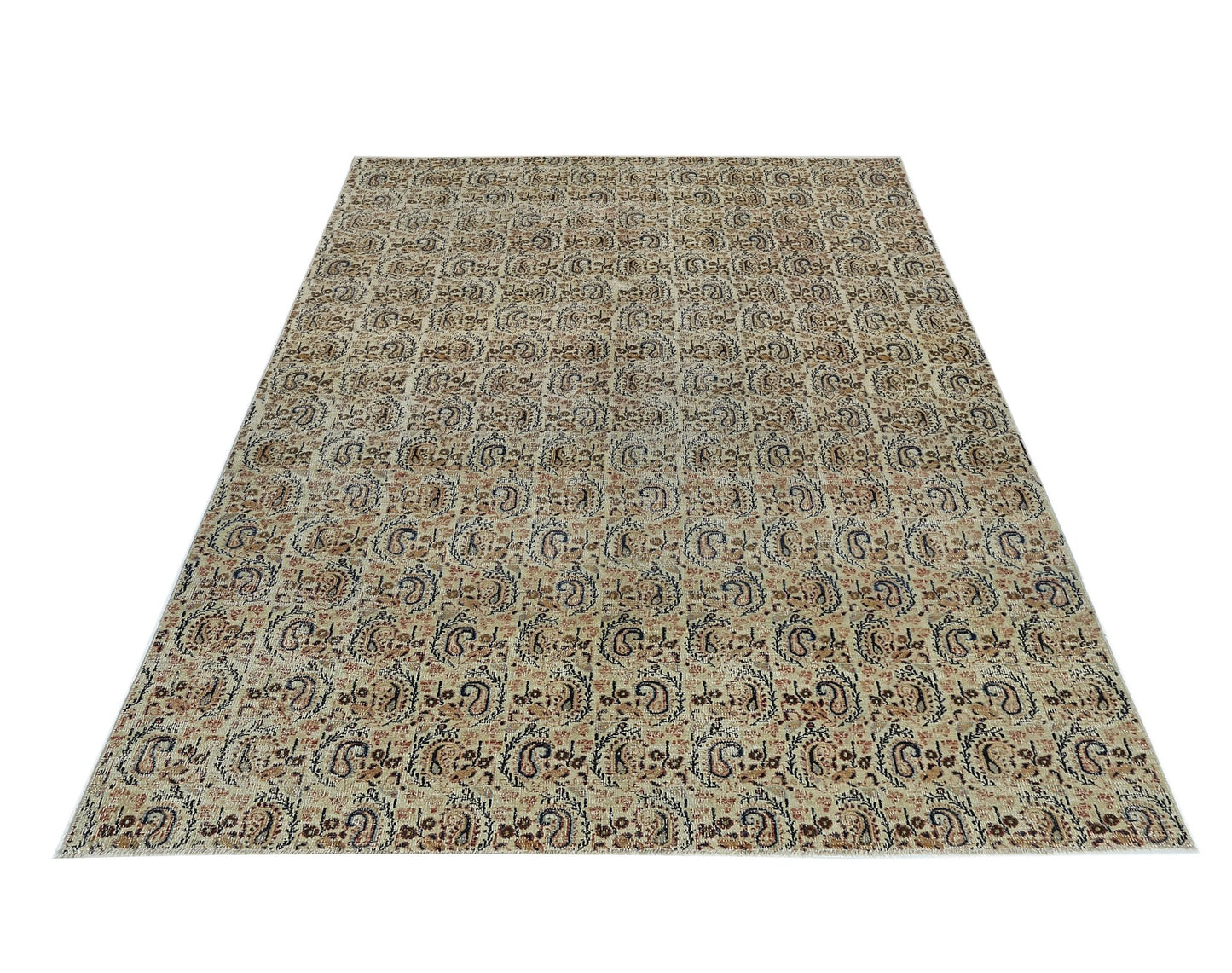 A rectangular vintage Turkish rug featuring a repeating paisley pattern in muted earth tones.