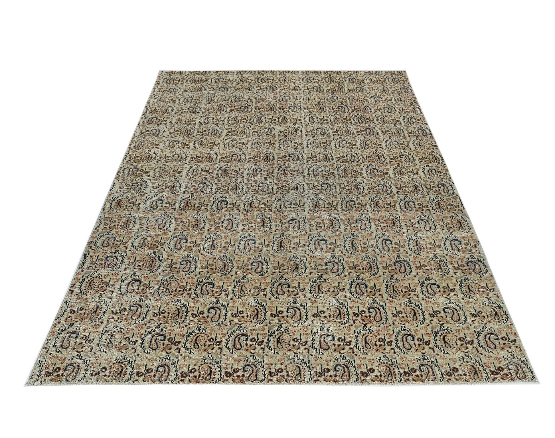 A rectangular vintage Turkish rug featuring a repeating paisley pattern in muted earth tones.