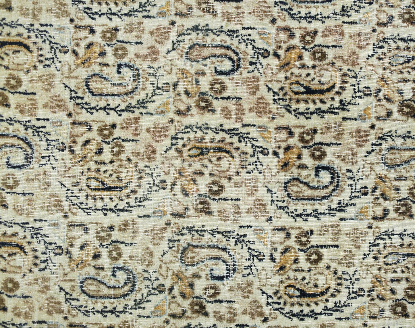 A vintage Turkish rug featuring a repeating paisley pattern in shades of brown, cream, and black.