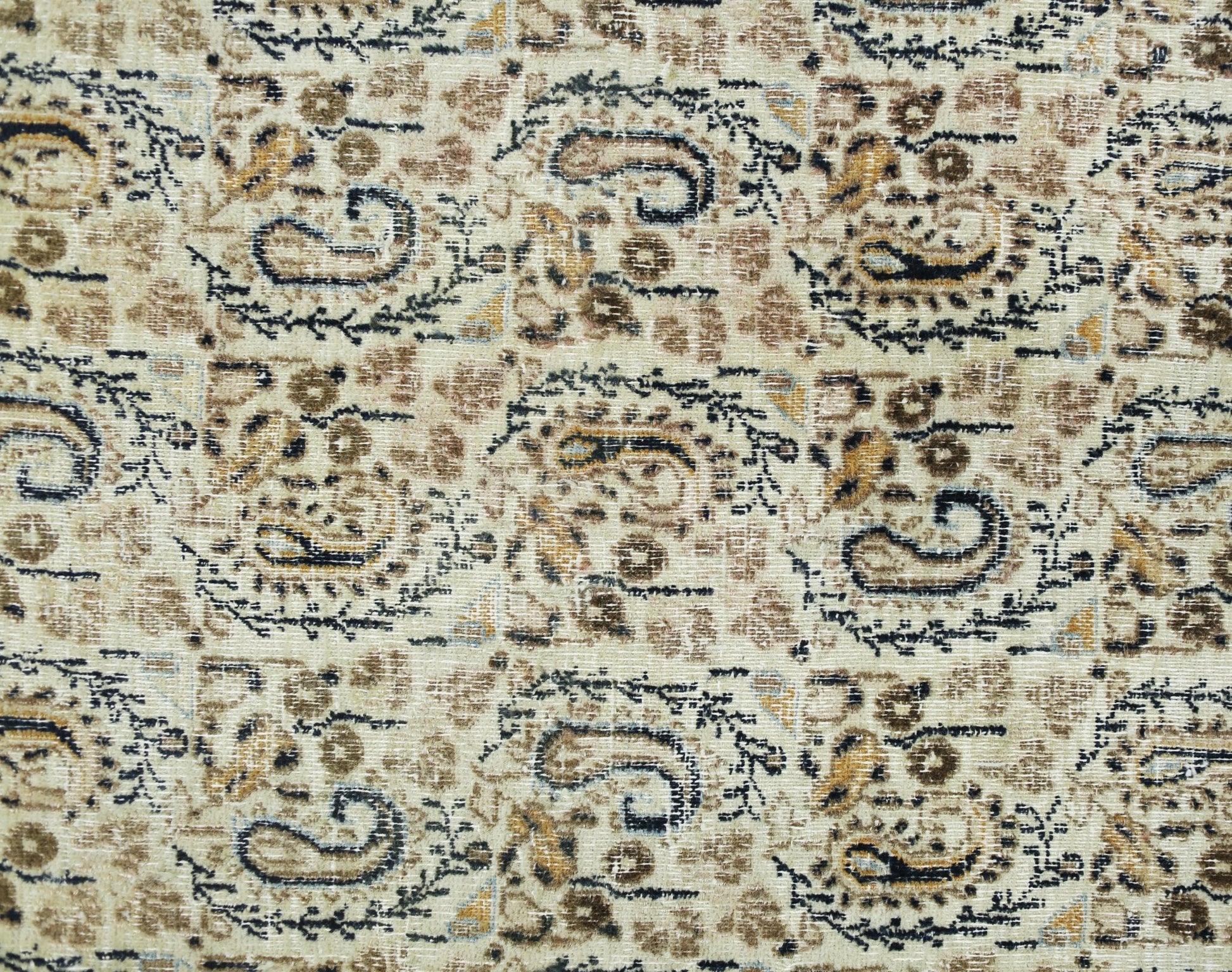 A vintage Turkish rug featuring a repeating paisley pattern in shades of brown, cream, and black.