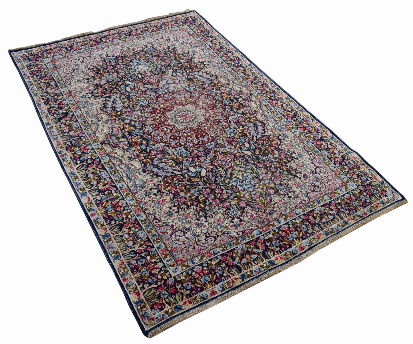 A vintage Persian Kerman rug featuring an intricate floral medallion design in deep blue and red.