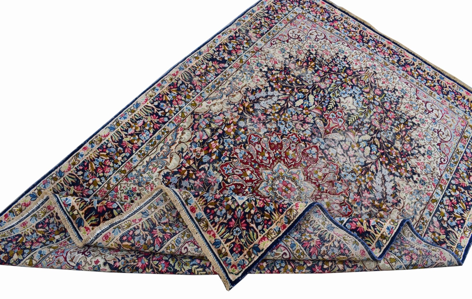 A vintage Persian Kerman rug featuring an intricate floral medallion design in blue and red tones.