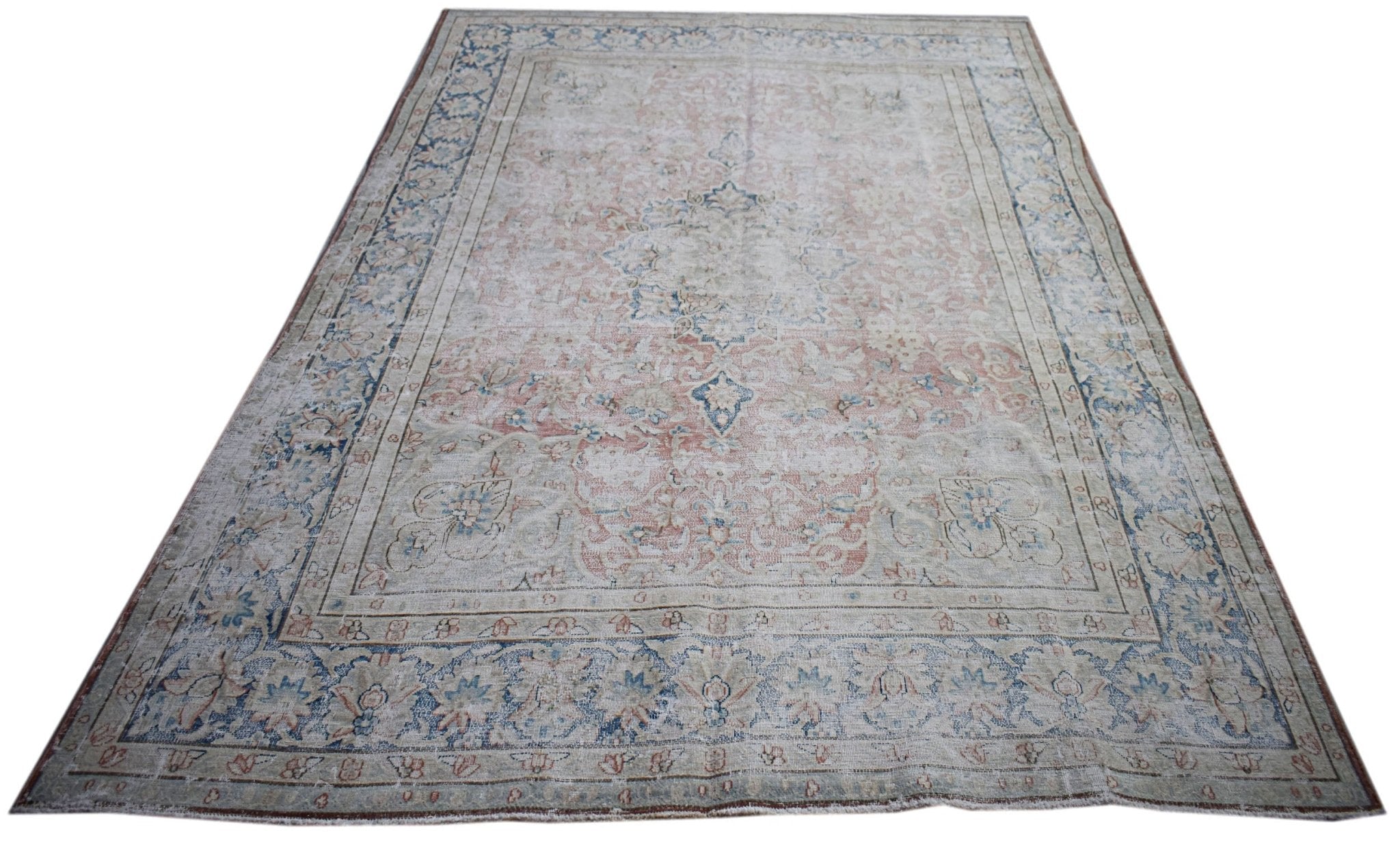 A vintage Persian Kerman rug featuring a central medallion and intricate floral patterns.