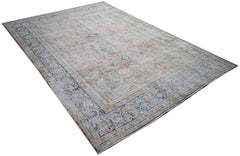 A vintage Persian Kerman rug featuring a faded floral medallion design in soft blue and pink tones.