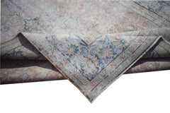 A vintage Persian Kerman rug featuring a faded floral medallion pattern in blue and soft pink.