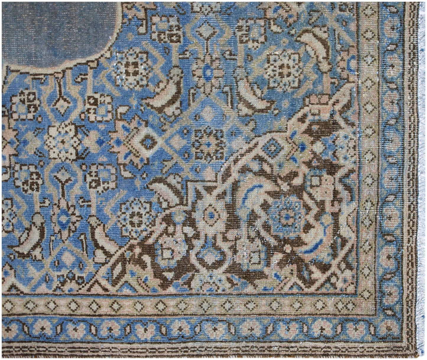 A vintage Persian Kerman rug featuring an intricate blue and brown floral medallion pattern.