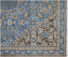A vintage Persian Kerman rug featuring an intricate blue and brown floral medallion pattern.