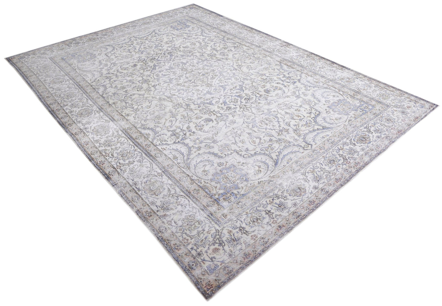 A vintage Persian Kerman rug featuring an intricate floral pattern in soft blue and cream tones.