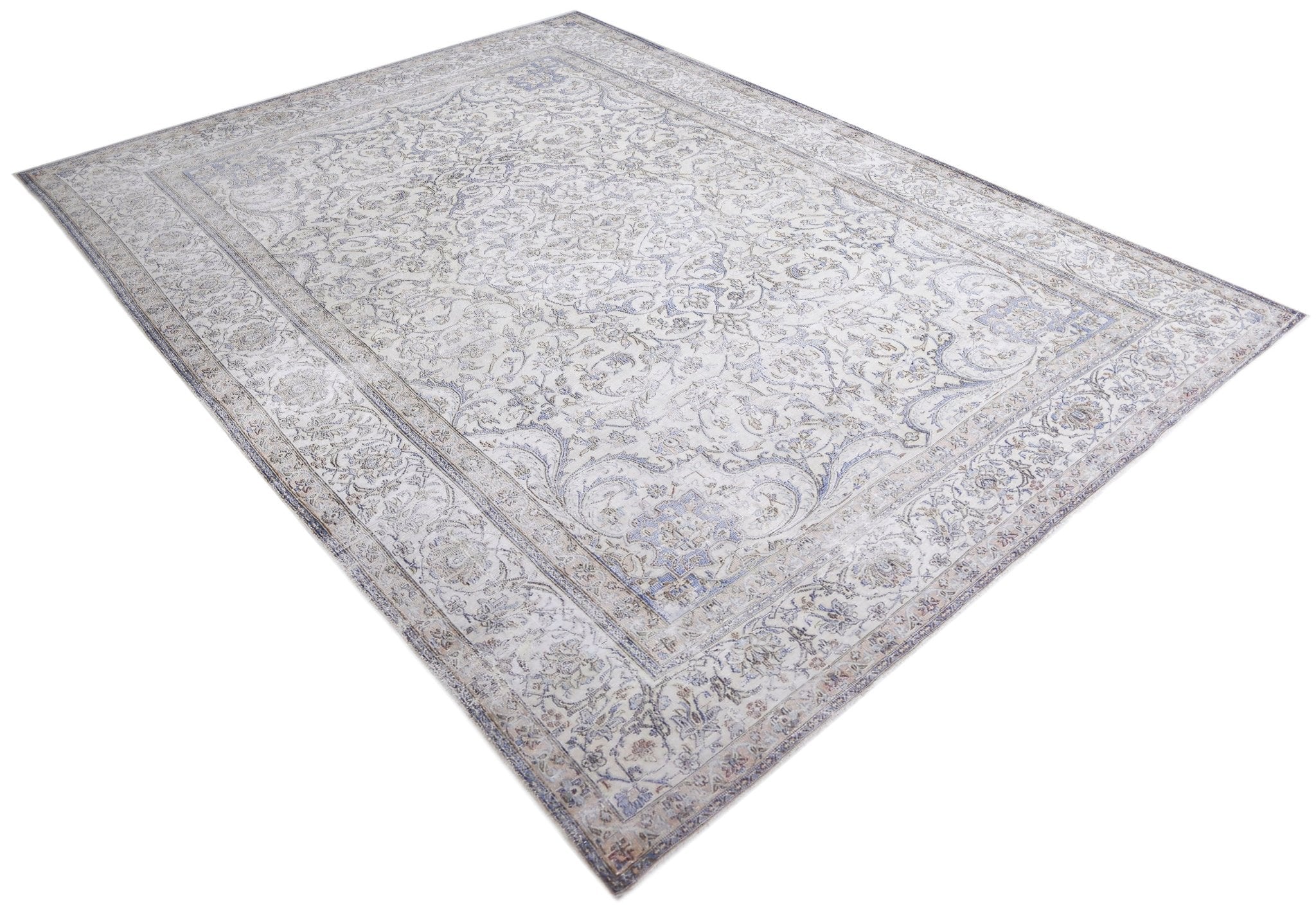 A vintage Persian Kerman rug featuring an intricate floral pattern in soft blue and cream tones.