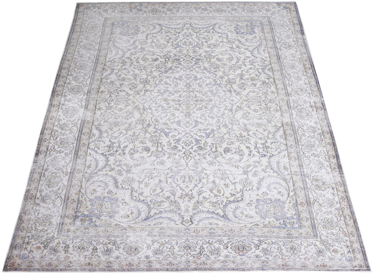 A vintage Persian Kerman rug featuring an intricate floral medallion design in soft blue and cream.