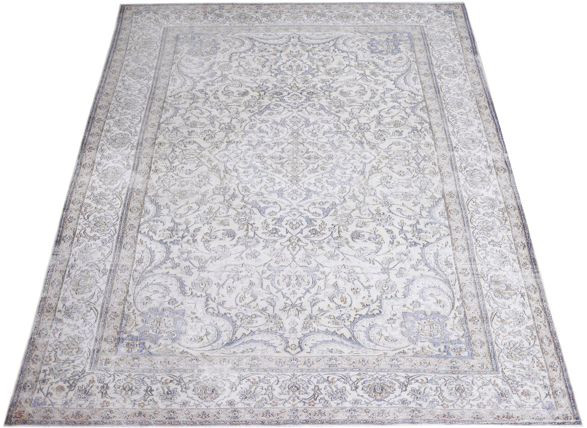 A vintage Persian Kerman rug featuring an intricate floral medallion design in soft blue and cream.