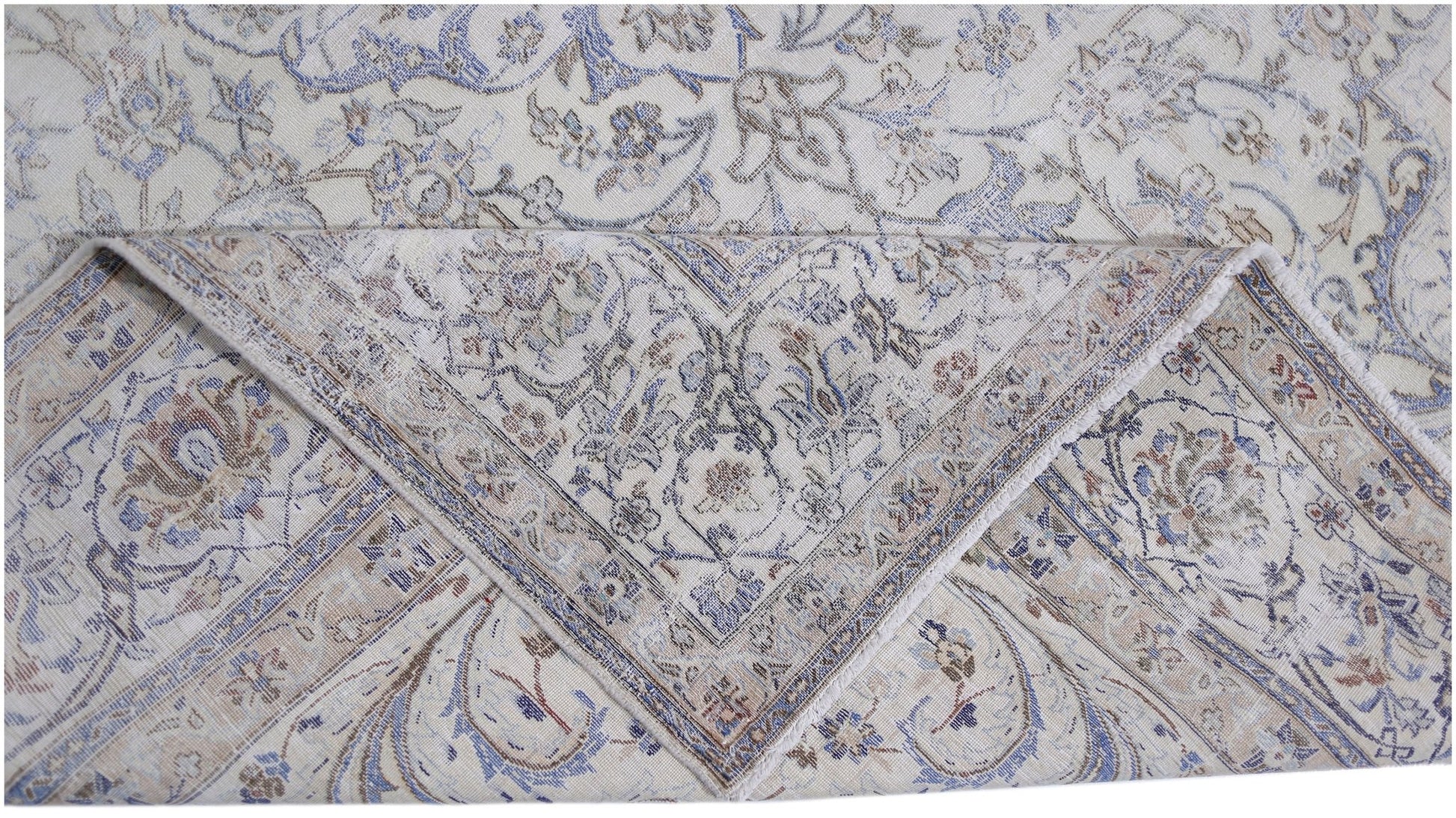 A vintage Persian Kerman rug featuring an intricate floral pattern in blue and beige tones.