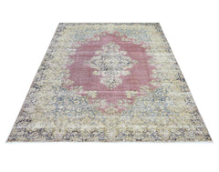 A vintage Persian Kerman rug featuring a central medallion and intricate floral patterns in pink.