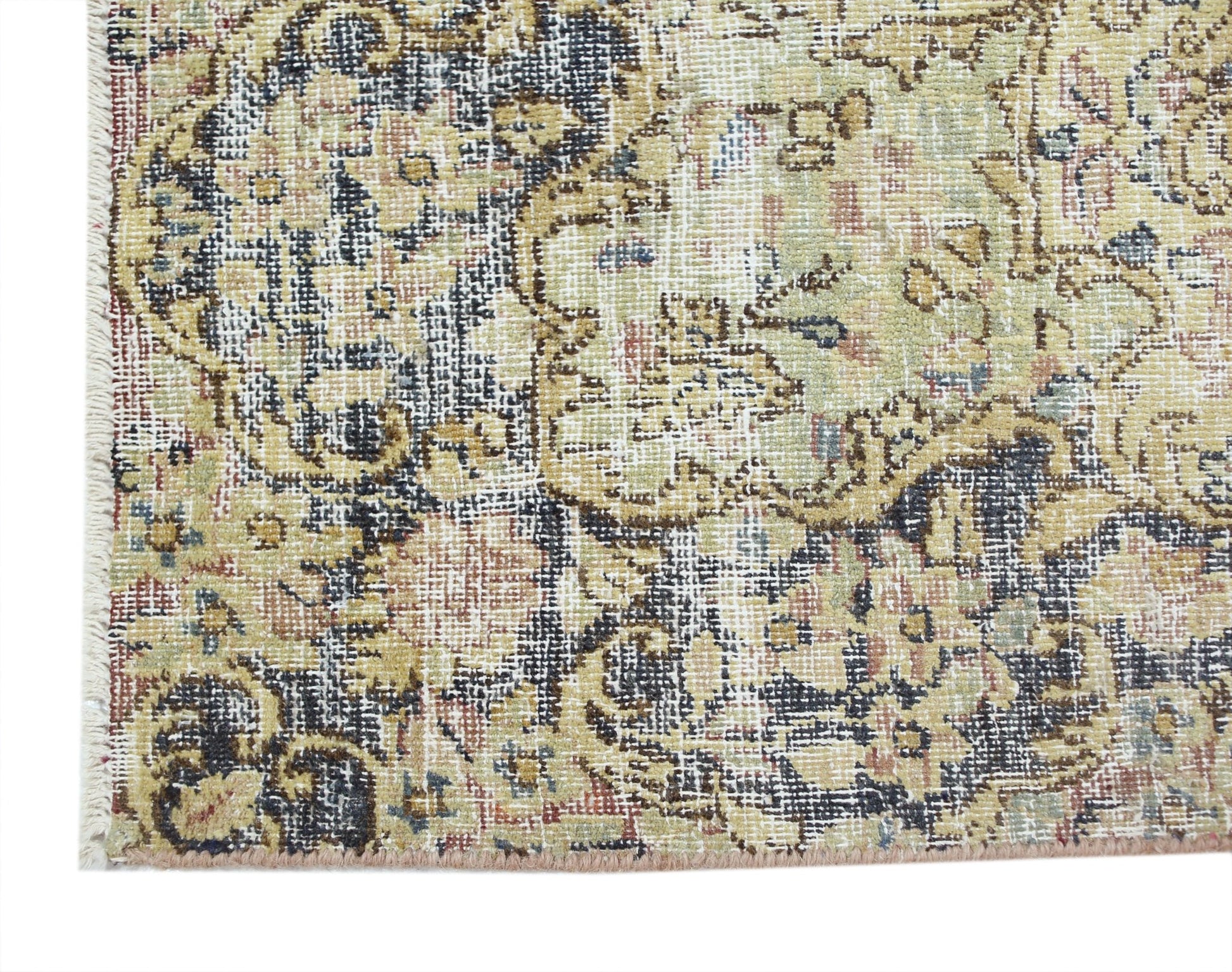 A close-up of a vintage Persian Kerman rug featuring intricate floral patterns in muted tones.