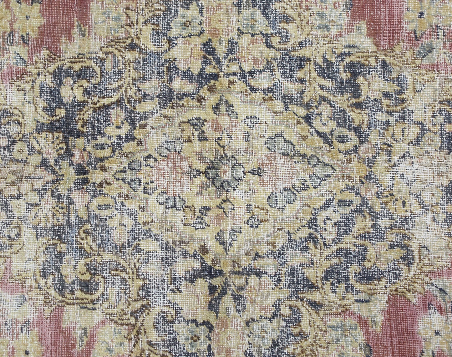 A vintage Persian Kerman rug featuring an intricate floral medallion in muted red, blue, and gold.