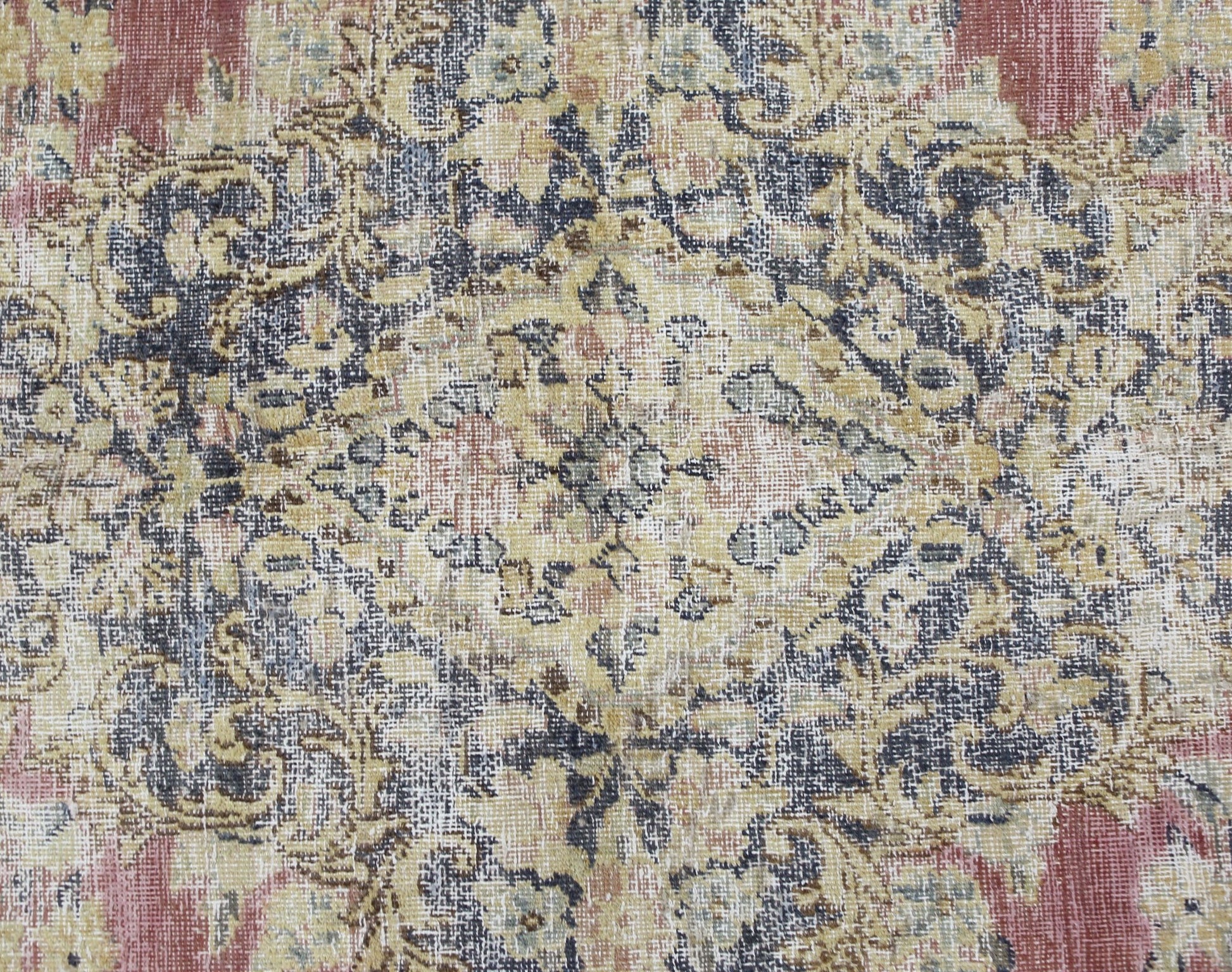 A vintage Persian Kerman rug featuring an intricate floral medallion in muted red, blue, and gold.