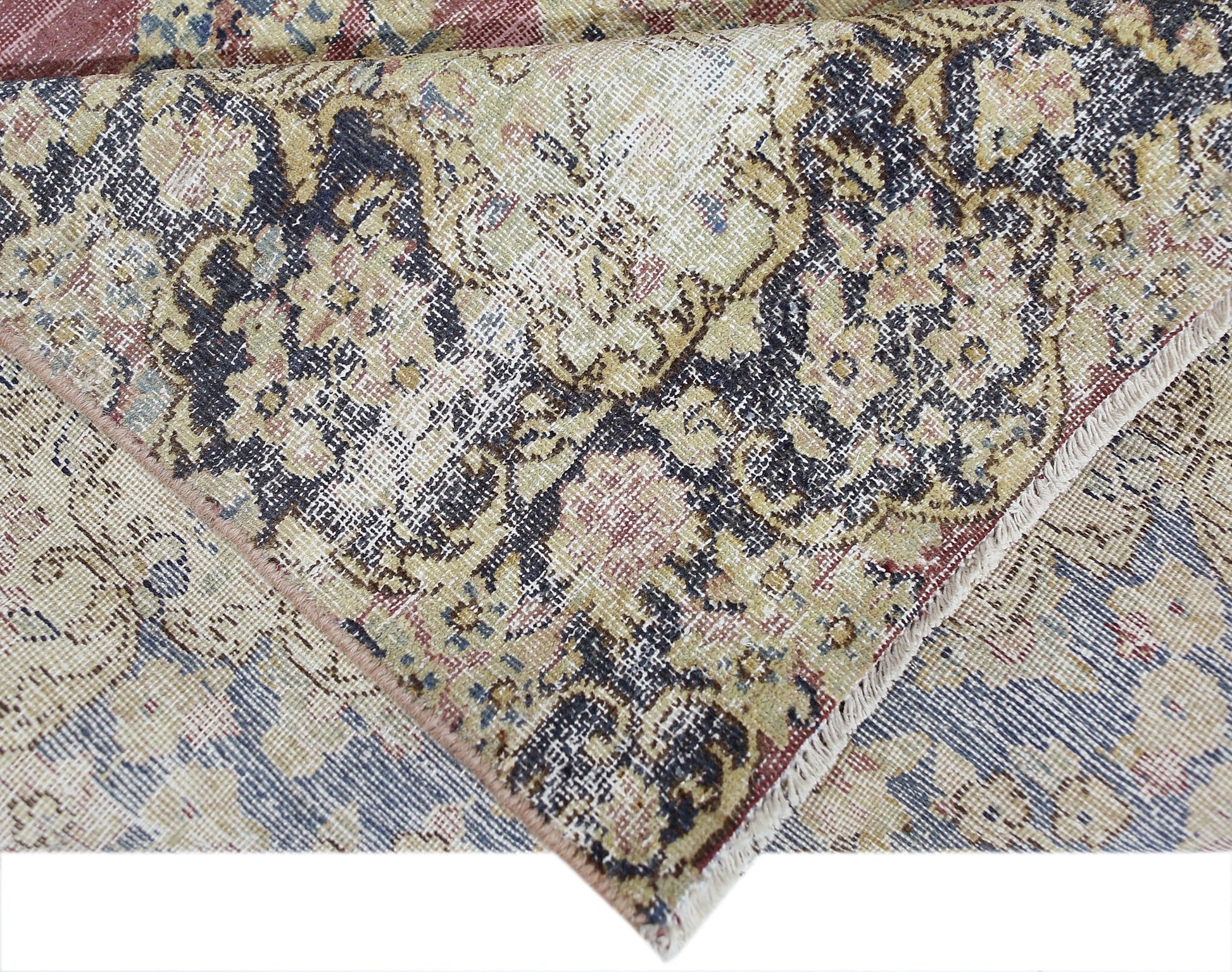 A vintage Persian Kerman rug featuring an intricate floral pattern in muted earth tones.