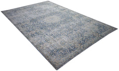A vintage Persian Kerman rug featuring an intricate blue and cream floral medallion design.