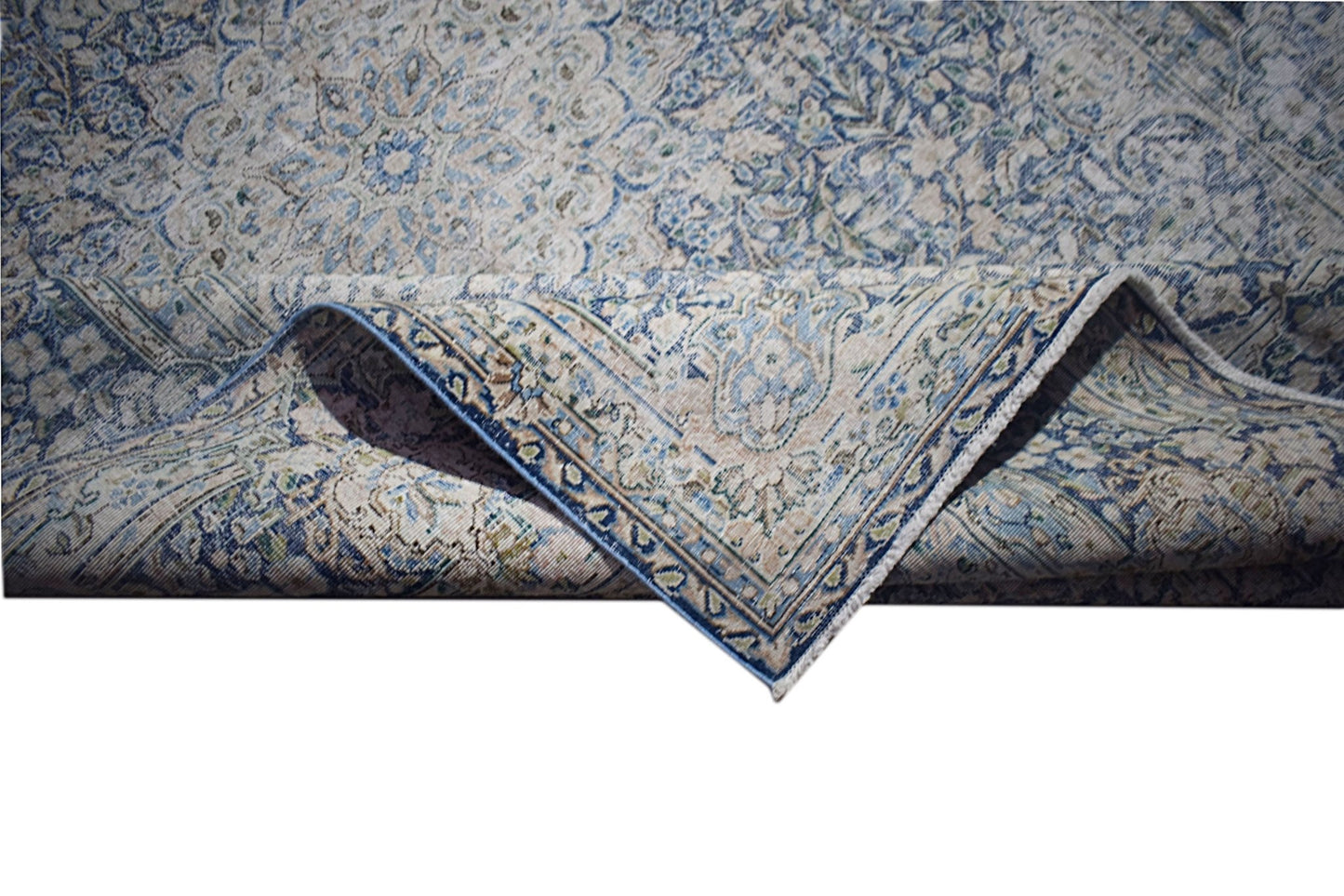 A vintage Persian Kerman rug featuring an intricate blue and cream floral medallion pattern.