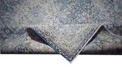 A vintage Persian Kerman rug featuring an intricate blue and cream floral medallion pattern.