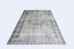 A vintage Persian Kerman rug featuring a central medallion and intricate floral patterns in blue.