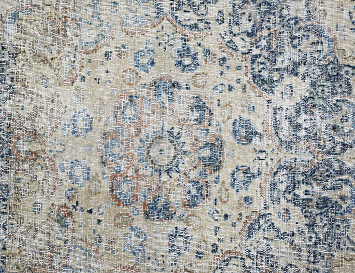 A vintage Persian Kerman rug featuring a central medallion with intricate blue and tan floral motifs.