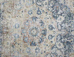 A vintage Persian Kerman rug featuring a central medallion with intricate blue and tan floral motifs.