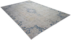 A vintage Persian Kerman rug featuring a central medallion and floral motifs in blue and beige.