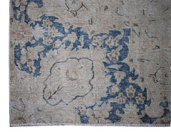 A vintage Persian Kerman rug featuring a faded blue floral medallion on a neutral beige background.