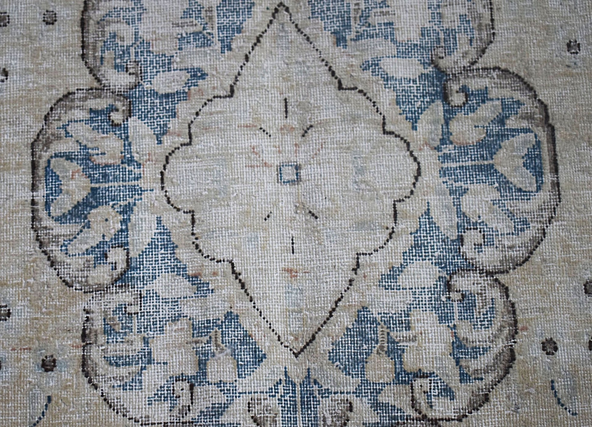 A vintage Persian Kerman rug featuring a central medallion with intricate blue floral patterns.