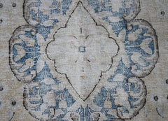 A vintage Persian Kerman rug featuring a central medallion with intricate blue floral patterns.