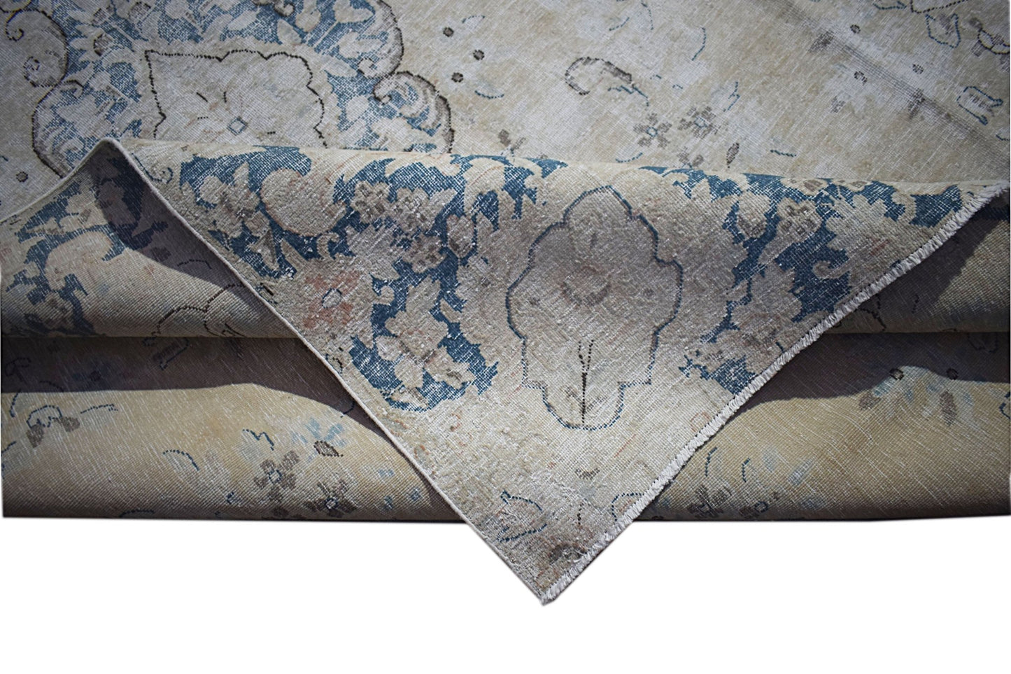 A vintage Persian Kerman rug featuring a blue floral medallion pattern on a beige background.