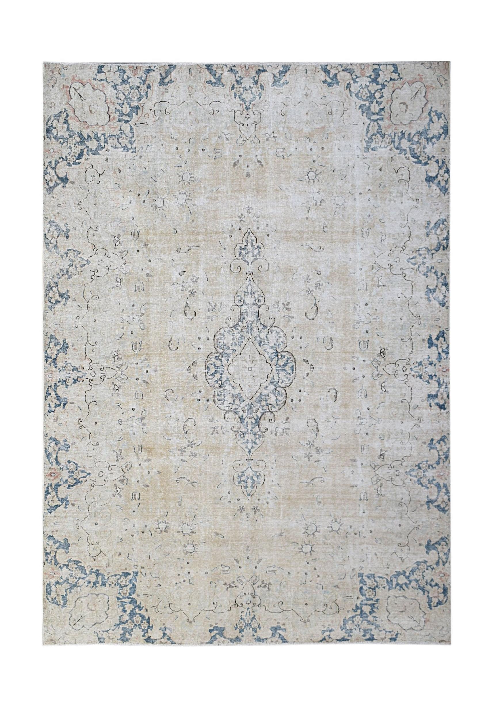 A vintage Persian Kerman rug featuring a central medallion and floral motifs in blue and beige.