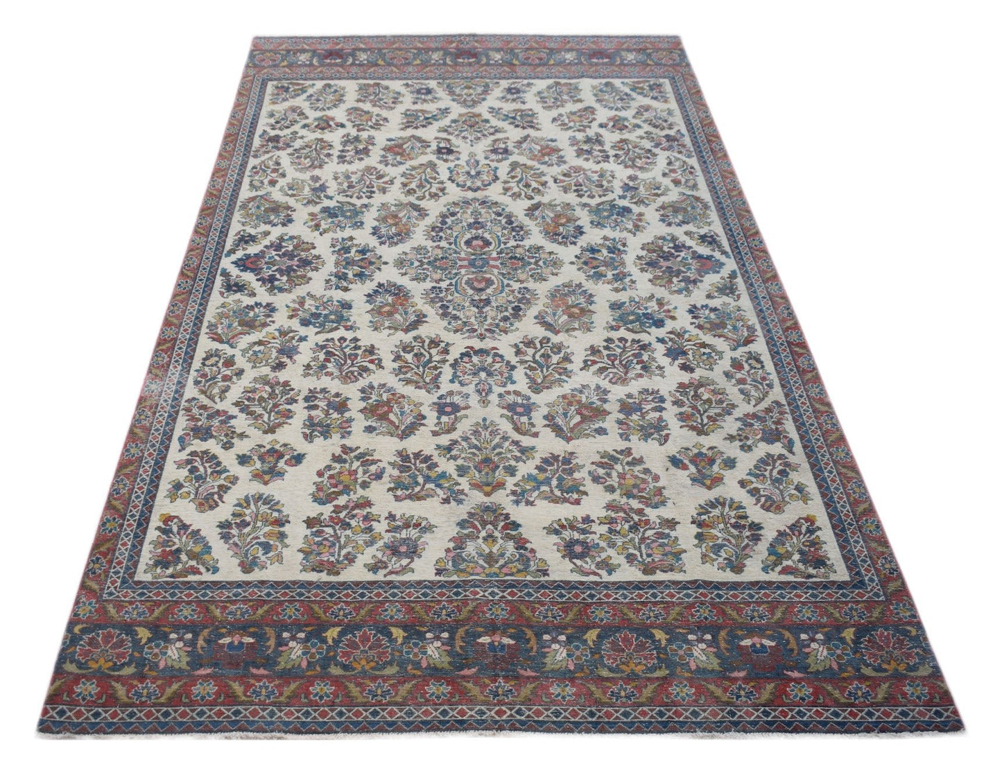 A vintage Persian Kerman rug featuring a central floral medallion on a cream field with ornate borders.