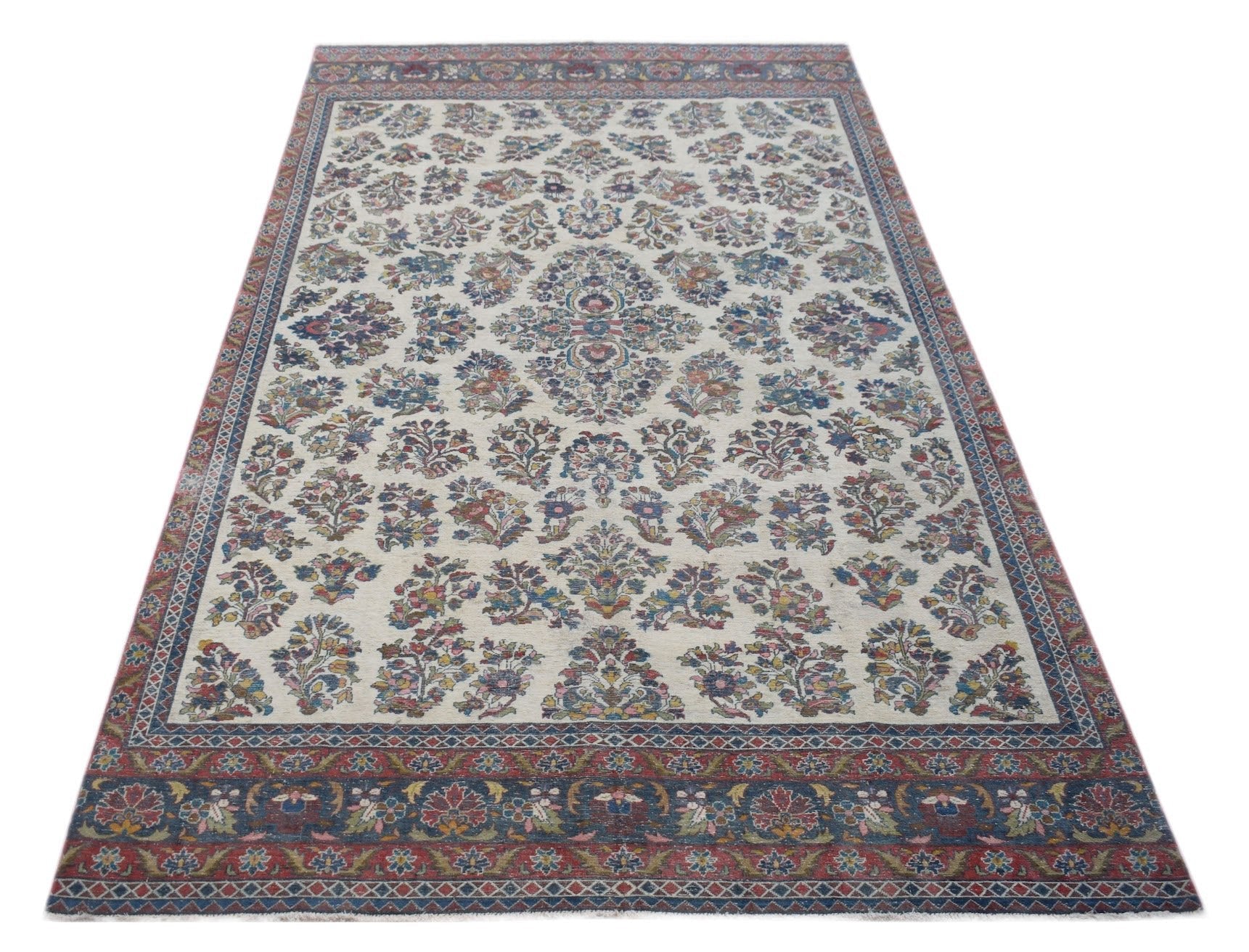 A vintage Persian Kerman rug featuring a central floral medallion on a cream field with ornate borders.