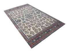 A vintage Persian Kerman rug featuring a central medallion and intricate floral patterns.