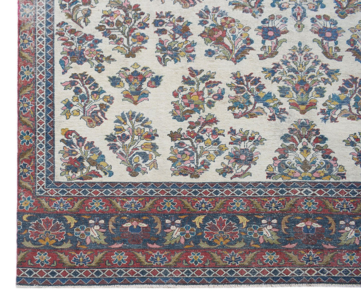 A vintage Persian Kerman rug featuring a cream field with intricate floral motifs and ornate borders.