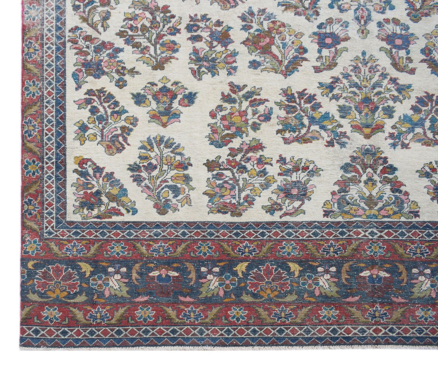 A vintage Persian Kerman rug featuring a cream field with intricate floral motifs and ornate borders.