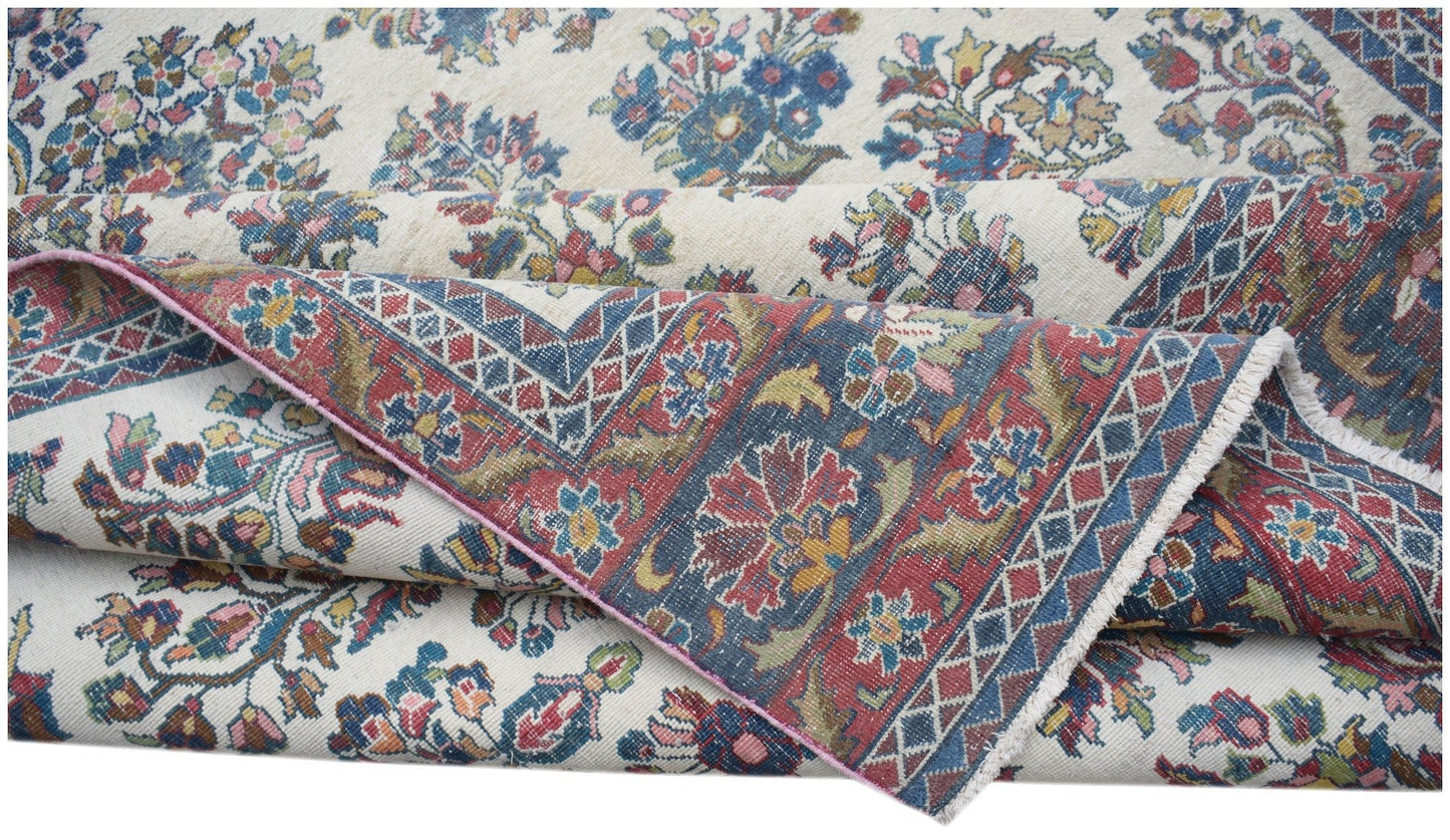 A vintage Persian Kerman rug featuring intricate floral patterns and a detailed border.