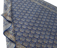 A vintage Persian Kerman rug featuring a dense blue field with an intricate repeating paisley motif.