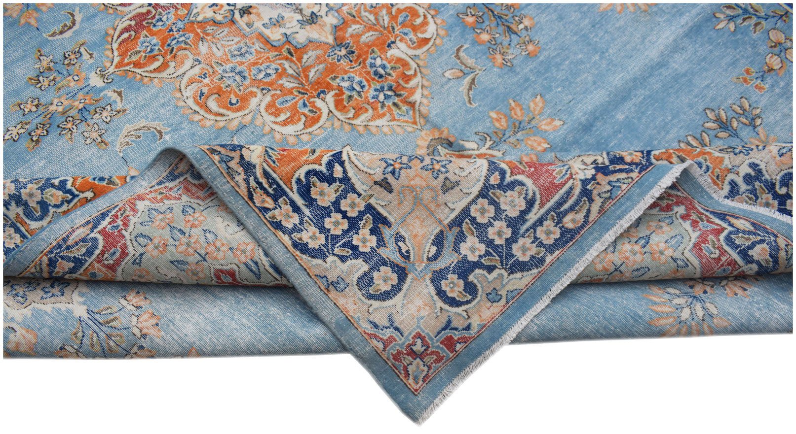 A vintage Persian Kerman rug featuring a blue field with intricate orange and floral patterns.