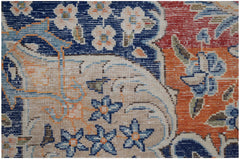 Close-up of a vintage Persian Kerman rug featuring intricate floral patterns in blue and orange.