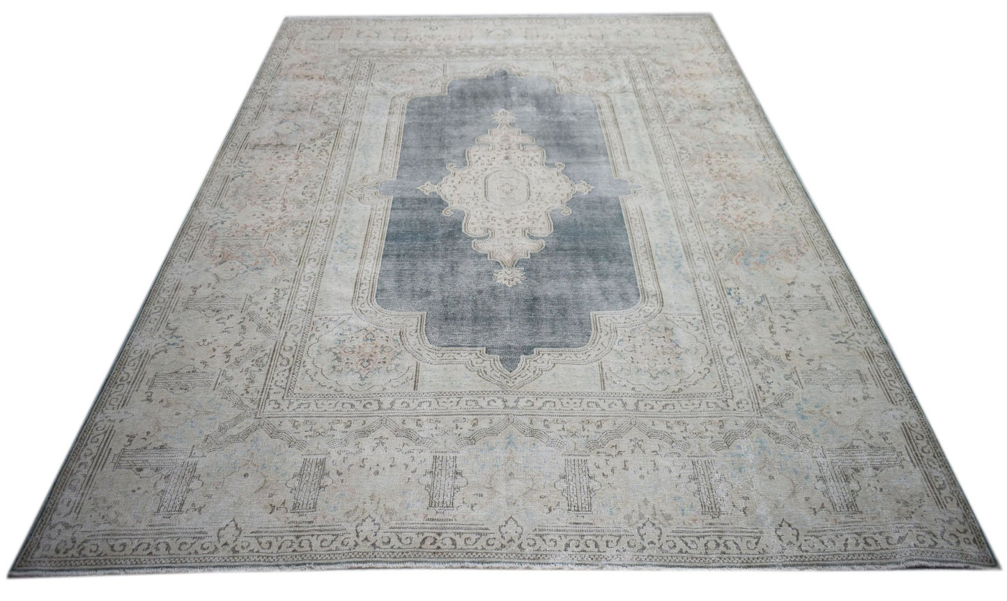 A vintage Persian Kerman rug featuring a central medallion on a grey field with floral motifs.