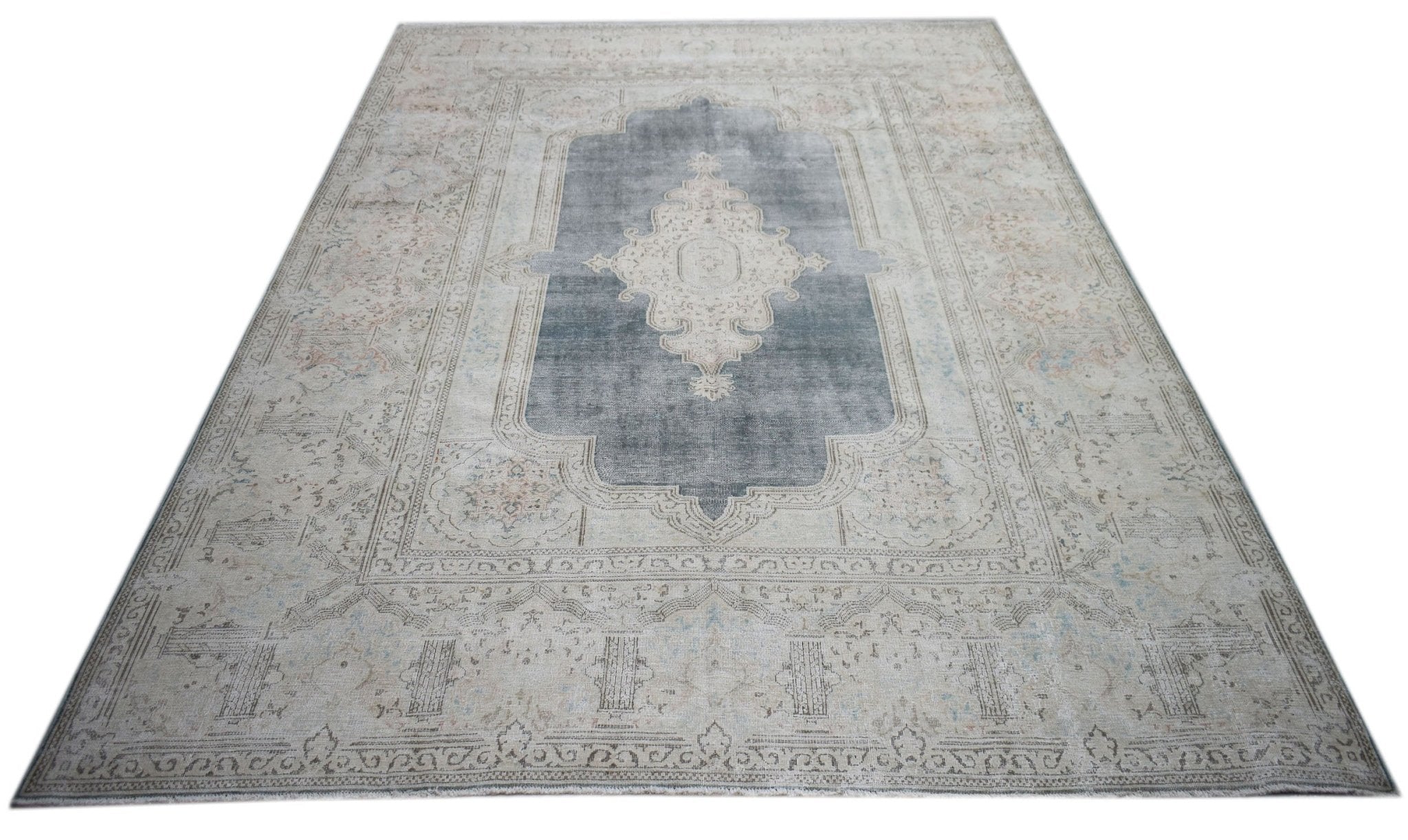 A vintage Persian Kerman rug featuring a central medallion on a grey field with floral motifs.