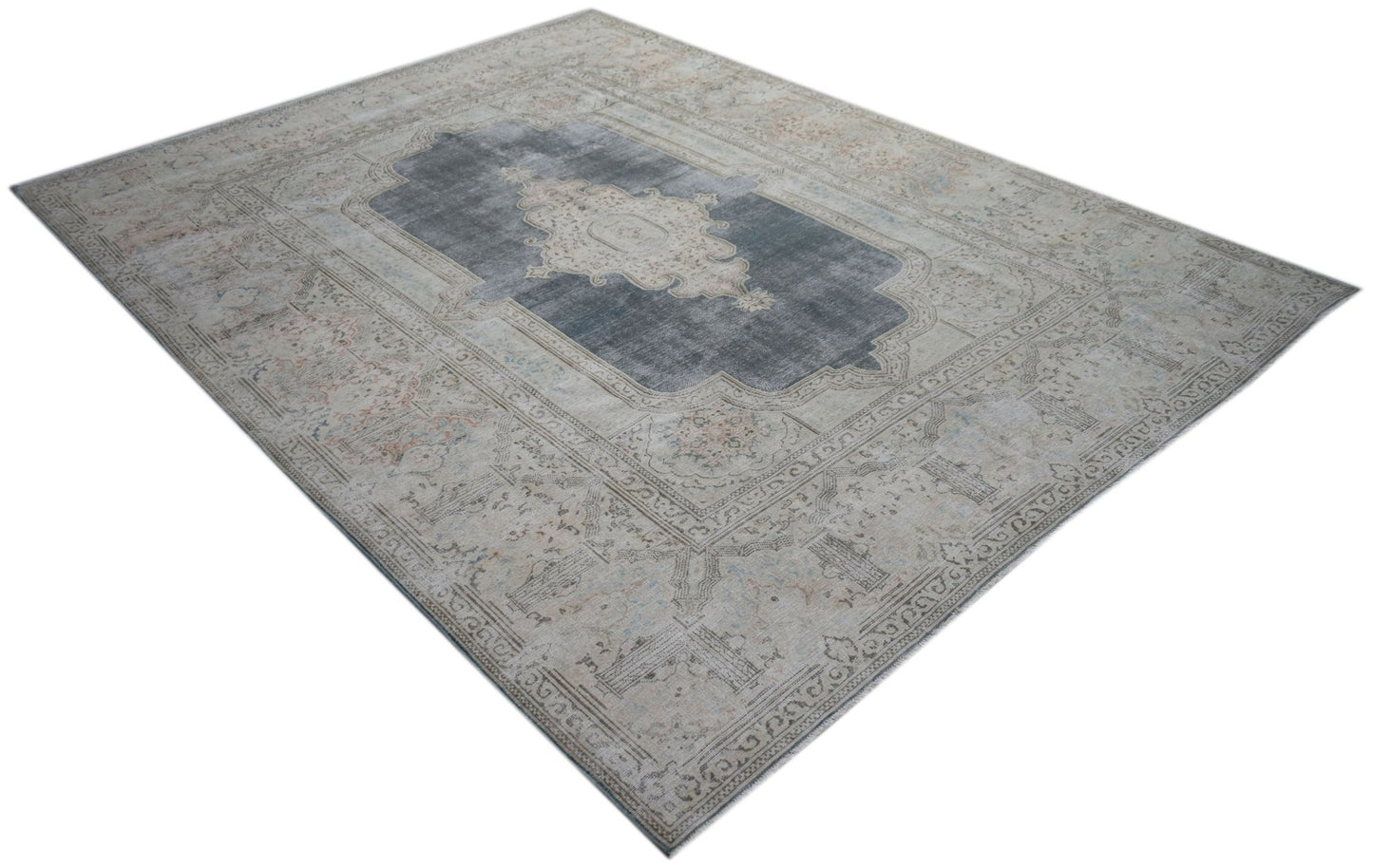 A vintage Persian Kerman rug featuring a central medallion on a grey field with floral borders.