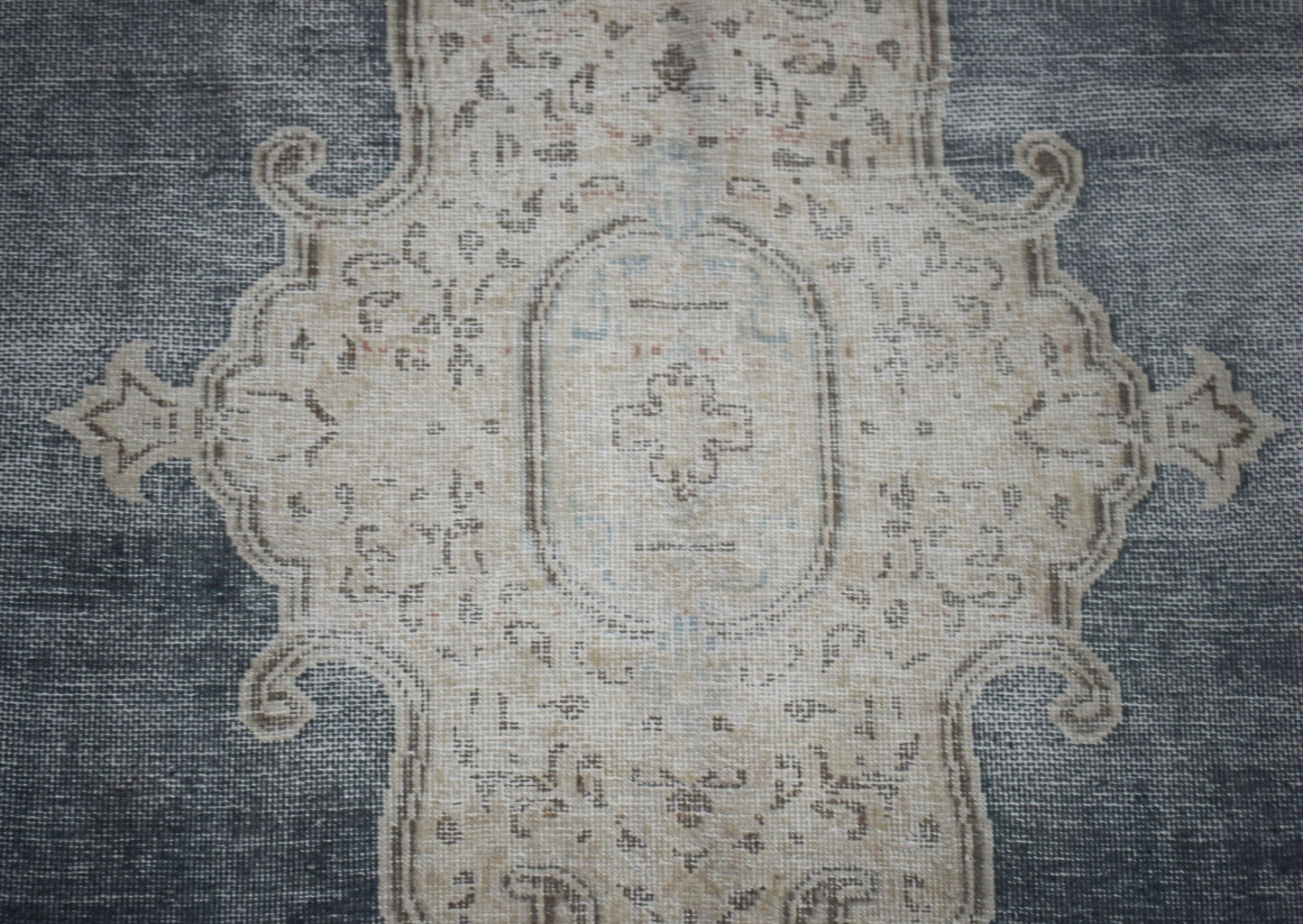 A vintage Persian Kerman rug featuring a central medallion with intricate floral patterns in grey.