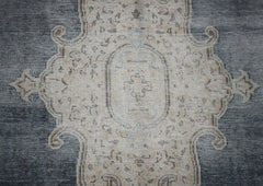 A vintage Persian Kerman rug featuring a central medallion with intricate floral patterns in grey.